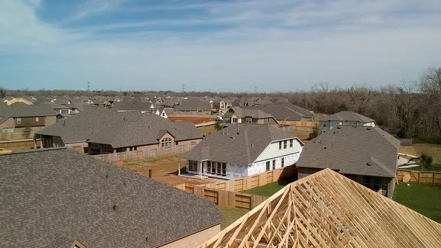 drone crane shot of new construction home to built homes in the background