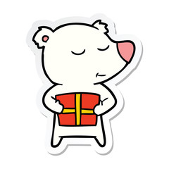 sticker of a happy cartoon polar bear with present