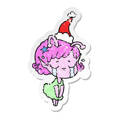 distressed sticker cartoon of a crying alien girl wearing santa hat