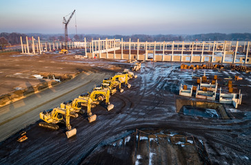 Luftbild - Industriearbeiten - Einige Bagger vor einen Hallenrohbau