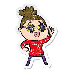 distressed sticker of a cartoon waving woman wearing sunglasses