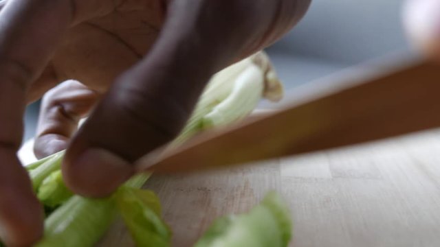 Closeup of celery being sliced.