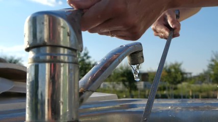 Young woman s hands washing a thin skewer over a garden sink in slow motion