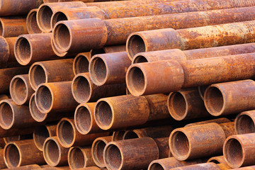 Pile of rusty metal pipes as industrial background