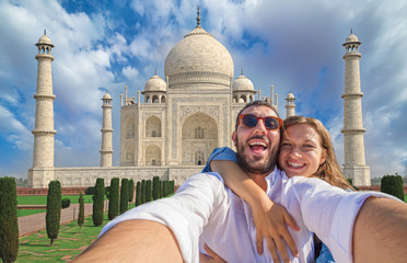 Tourism in India. Handsome couple in love in holiday using mobile phone to take selfie picture at...
