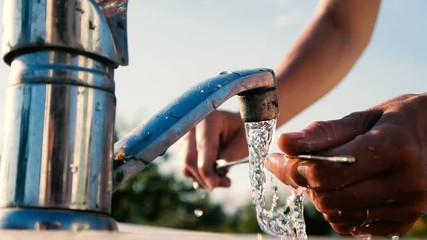 Strong female hands scouring a sparkling skewer over a garden sink in slo-mo
