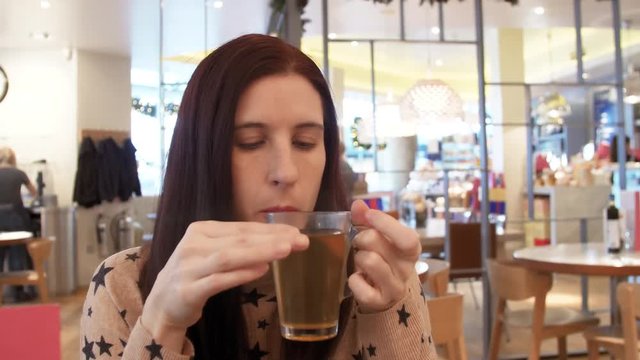 woman enjoys a sip of tea in a posh coffee shop