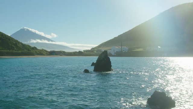 Stunning turquoise water of Porto Pim bay, Horta with Mount Pico in the background