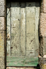 old green wooden door with stone walls