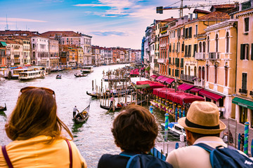 Fototapeta na wymiar Familia de vacaciones en Venecia Italia, mirando al gran canal desde el puente Rialto