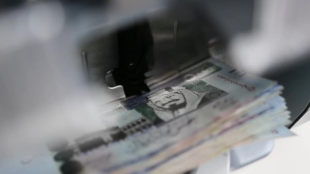Cash money counting machine. Banknote counter are counting five hundred Saudi Riyal bills