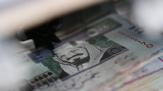 Cash money counting machine. Banknote counter are counting five hundred Saudi Riyal bills