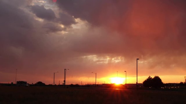 Time-lapse shot of dramatic storm clouds at sunset with traffic.
