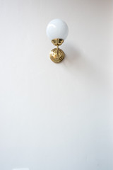 Golden lamp in vintage style hanging on empty wall background