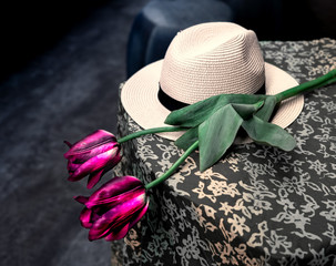 White biege woman hat and rose flower on the top of table with tablecloth. Concept of waiting for romantic true love and dating. Selective focus