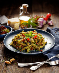 Penne pasta with spinach, sun dried tomatoes and chicken, sprinkled with parmesan cheese and fresh parsley