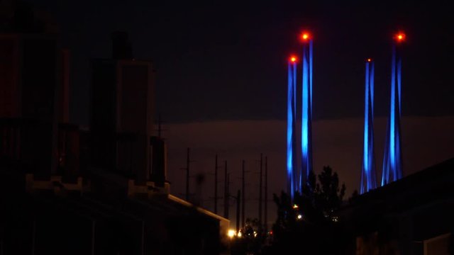 Modern style buildings and Indian River Inlet Bridge towers in time-lapsed motion. At nightfall with traffic headlights.