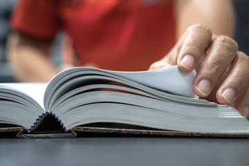 Reading book and education learning concept : Young man opening textbook for reading or searching information in knowledge.