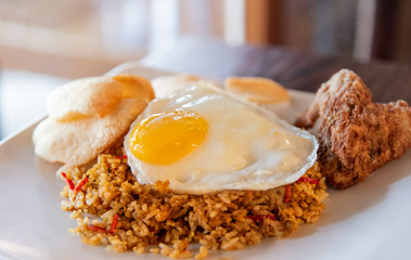 Chilly fried rice with sunny side egg up on white plate. Traditional indonesia and asian food. Selective focus.