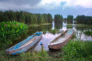 Old wooden boat harbour on the lakeside. Balinese traditional boat known as Jukung on Batur lake. Concept of searching for peaceful mind and happiness.