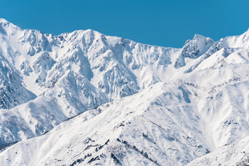 Fototapeta na wymiar 白馬村の雪山と青空の雪景色