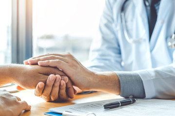 Doctor holding hands for comforting and care patient