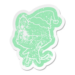 bored cartoon distressed sticker of a cat wearing santa hat