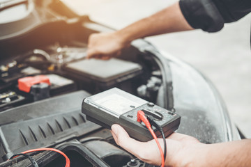 Auto mechanic working in garage Technician Hands of car mechanic working in auto repair Service and Maintenance check car battery.