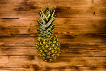 Whole ripe pineapple on a wooden table