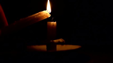 Close up footage of a candle being lit in a dark room during a power failure