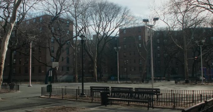 Empty courtyard in Queens, NY with basketball court in government housing facility during winter.