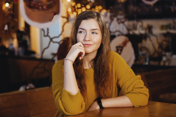 Portrait of beautiful young woman in cafe.