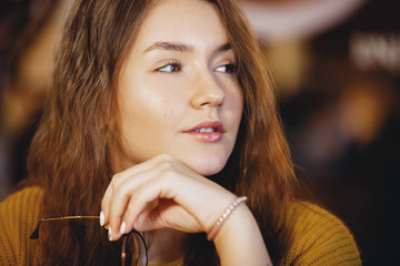 Portrait of beautiful young woman in cafe.