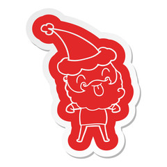 man with beard sticking out tongue wearing santa hat