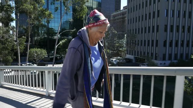 Homeless African American woman walks downtown.