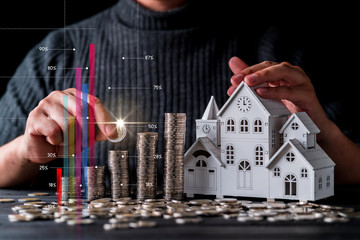 business mortgage financial ideas with businessman hand and money coin stack with house wooden...