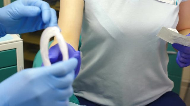 Tooth treatment. Closeup shot of female dentist assistant in gloves opening package with sterile mouth expander. Preparation for medical examination. dentist in his office prepares expander for mouth