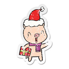 happy distressed sticker cartoon of a pig with xmas present wearing santa hat