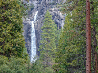 Twin waterfalls cascade over granite cliffs in Yosemite National Park, CA