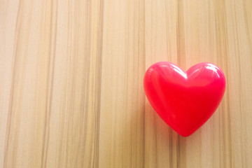  Heart on wood background close up image.