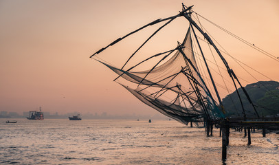 Obraz na płótnie Canvas Chinese fishing nets during the Golden Hours at Fort Kochi, Kerala, India sunset