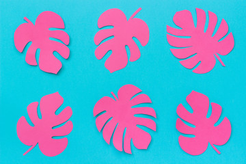 Fototapeta na wymiar Bright trendy pink tropical leaves monstera of paper on blue background. Flat lay Top-view creative paper art