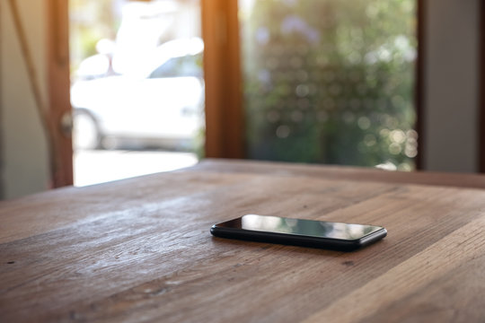 A Single Mobile Phone On Wooden Table