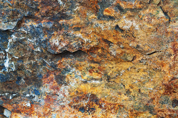 Yellow-red-brown black background from iridescent sandstone close-up