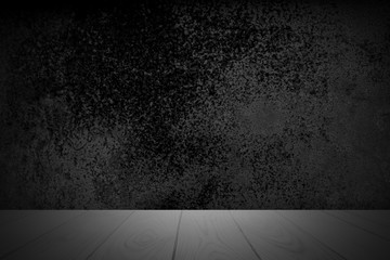 Empty wooden deck table over abstract black background with rough distressed aged texture for present product.