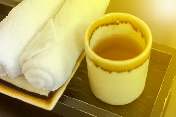 white cup of tea with towels on wood plate