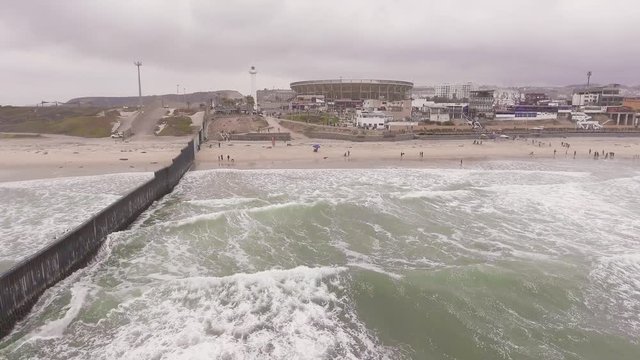Aerial drone shot of the U.S.-Mexico border fence as it reaches the Pacific Ocean in the cities of Tijuana (Mexico) and San Diego (U.S.)