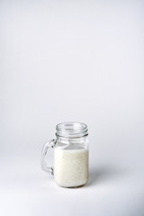 Protein cocktail, smoothie with milk, vanilla in a glass jar with straws.