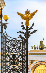 Fototapeta na wymiar Russian coat of arms imperial double headed eagle on Hermitage gate in Saint Petersburg Russia and Arch of Triumph in background