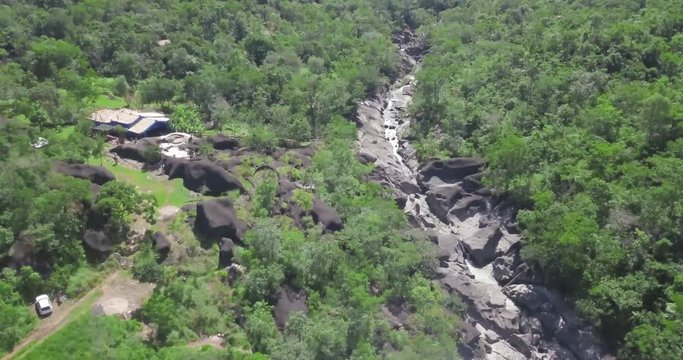 Aerial, secluded houses in beautiful Chapada Brazil Highlands, river flowing through jungle 4k